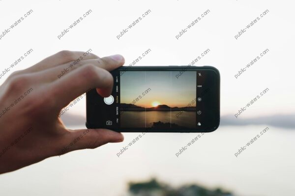 person taking picture on mountain with sun
